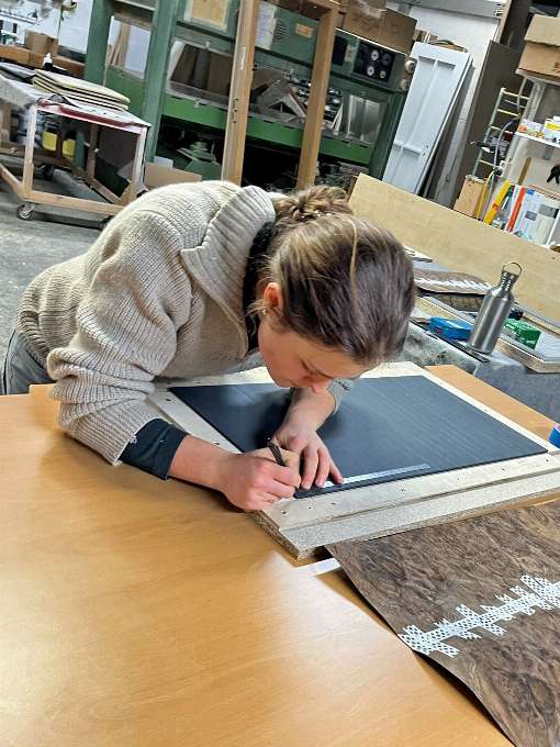 Bild 3: Johanna Thielges arbeitet konzentriert an einem Mbelstck. Das ausgewhlte Furnierblatt ist bereits fr die Weiterverarbeitung vorbereitet. Foto: Kevin Thielges